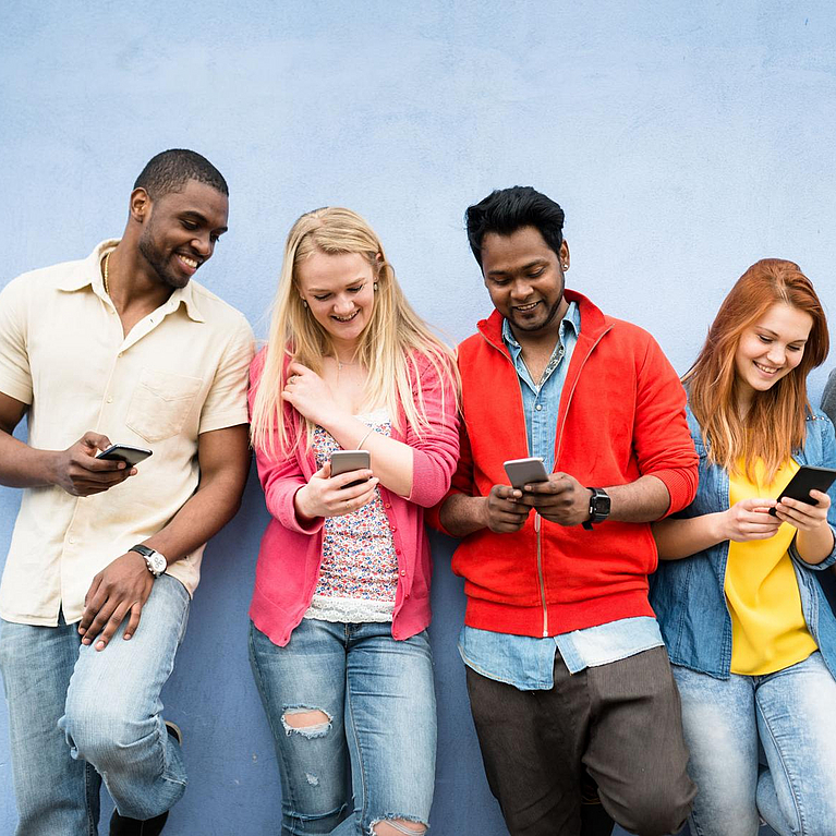 Gruppe von Jugendlichen schaut auf ihr Handy