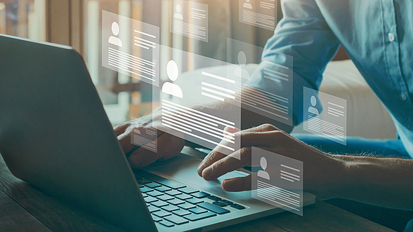 © anyaberkut – istock.com  Person sitzt am Computer und sucht Stellenanzeigen