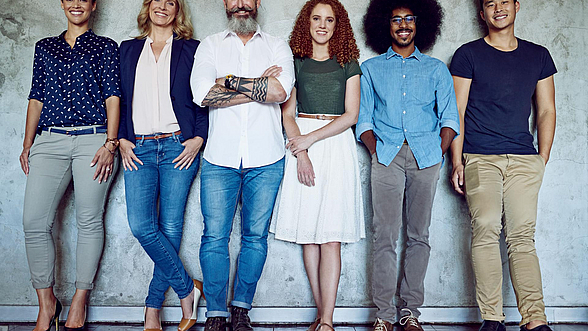 ©  PeopleImages – istock.com  Divers aussehende Personen stehen in einer Reihe